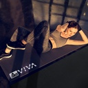 Vrouw bij buikspiertraining op de AsVIVA vloerbeschermmat UM2 in een donkere studio